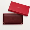 Internationale Geldbörse mit Seitenfalten, Must de Cartier – burgunderrotes Kalbsleder, goldfarbenes Finish – Cartier