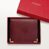 Mehrfach-Geldbörse, Must de Cartier – Burgunderrotes Kalbsleder, goldene Oberfläche – Cartier